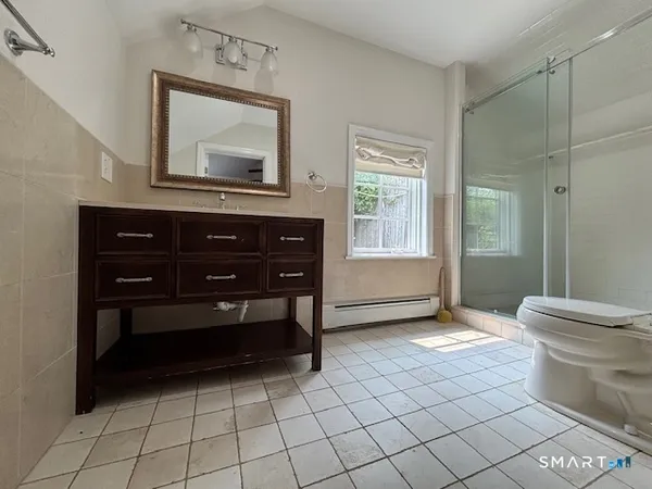 a spacious bathroom with a toilet sink and mirror