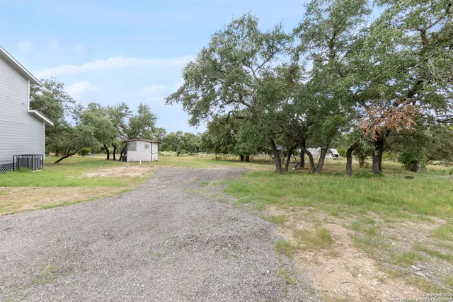 a view of a big yard with large trees