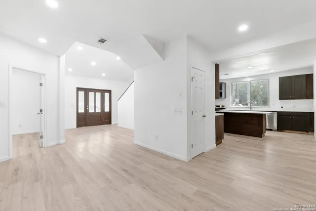 a view of an empty room with a fireplace and a window