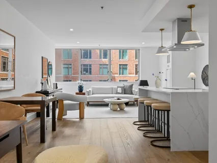 a living room with furniture a rug and white walls