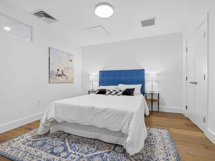 a bedroom with a bed and wooden floor