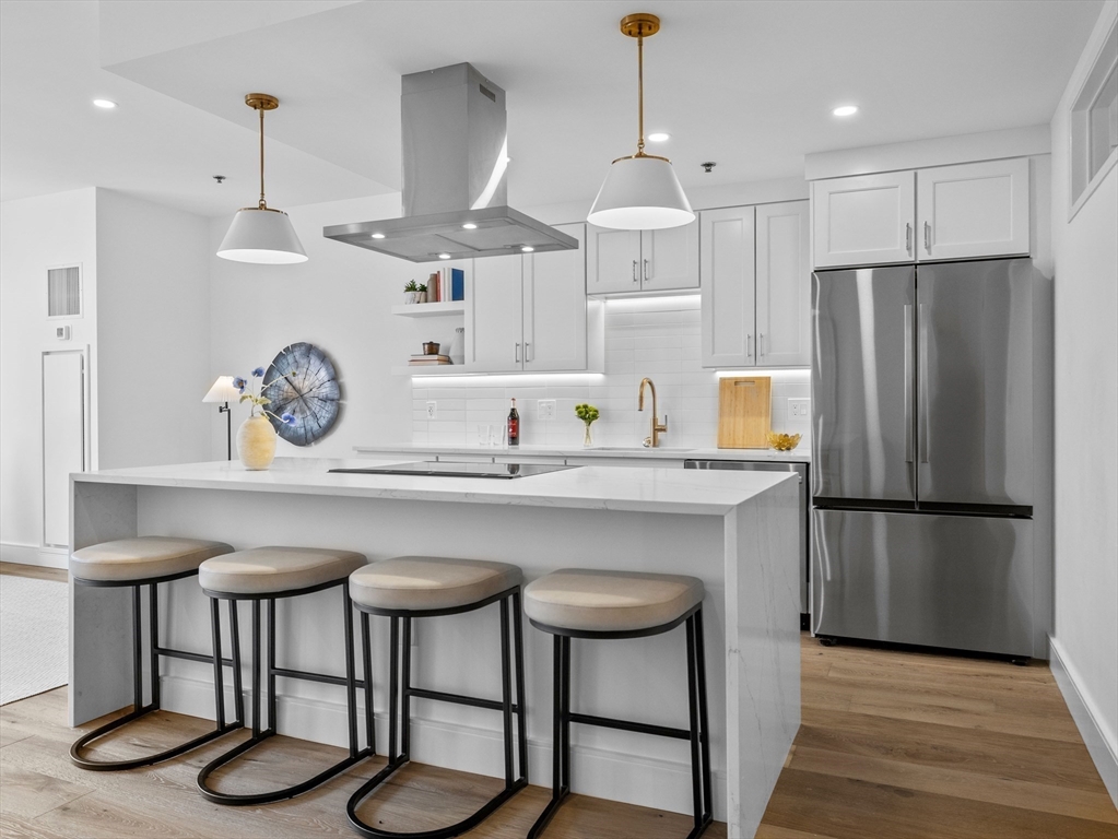 234 Causeway Street, Unit U702 Boston, MA 02114 - Photo 3 of 27 a kitchen with stainless steel appliances granite countertop a table chairs stove and refrigerator