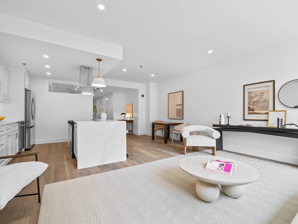 234 Causeway Street, Unit U702 Boston, MA 02114 - Photo 4 of 27 a living room with kitchen island furniture and a dining table with wooden floor
