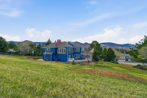 a view of a big house with a big yard and large trees