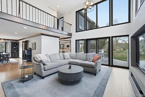 a living room with furniture a flat screen tv and a floor to ceiling window