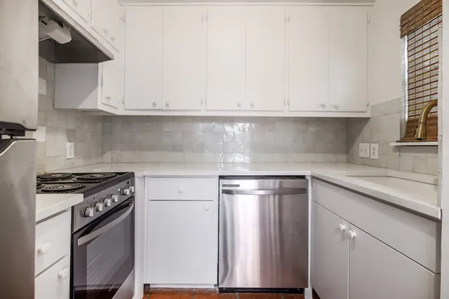 a kitchen with stainless steel appliances granite countertop a sink and a stove