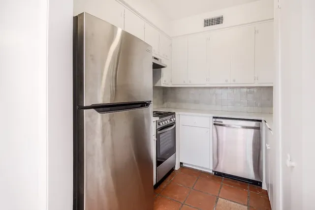 a metallic refrigerator freezer sitting in a kitchen