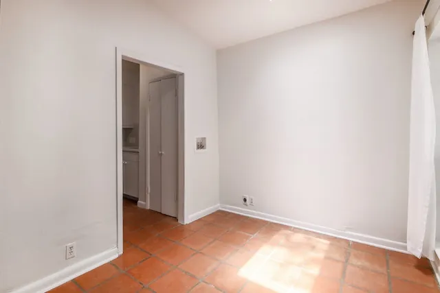 a view of a small space with wooden floor and a window