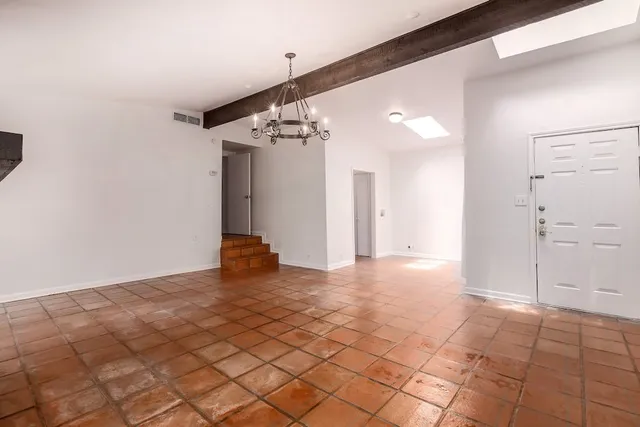 a view of a big room with wooden floor and windows