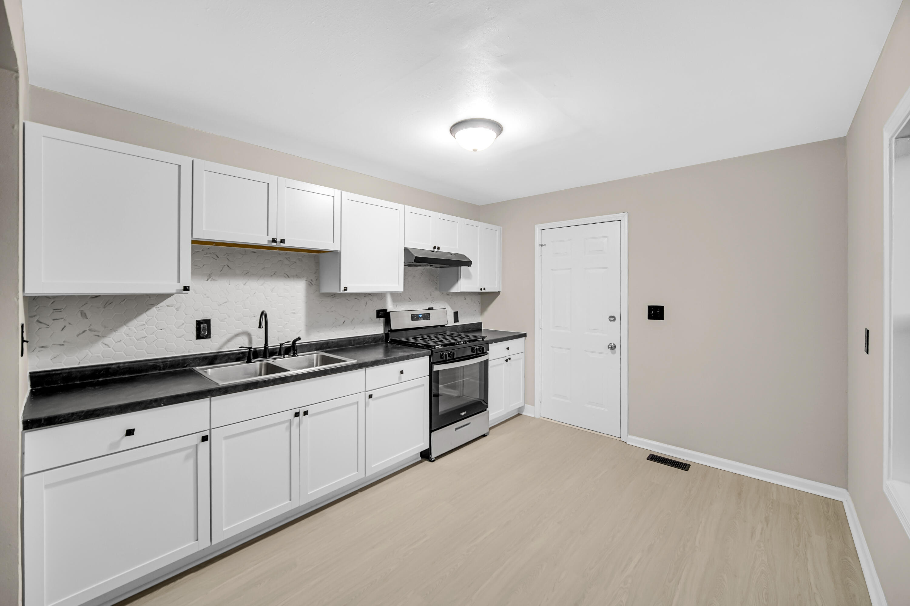 625 South Wells Street Gary, IN 46403 - Photo 6 of 18 a kitchen with granite countertop white cabinets and white appliances
