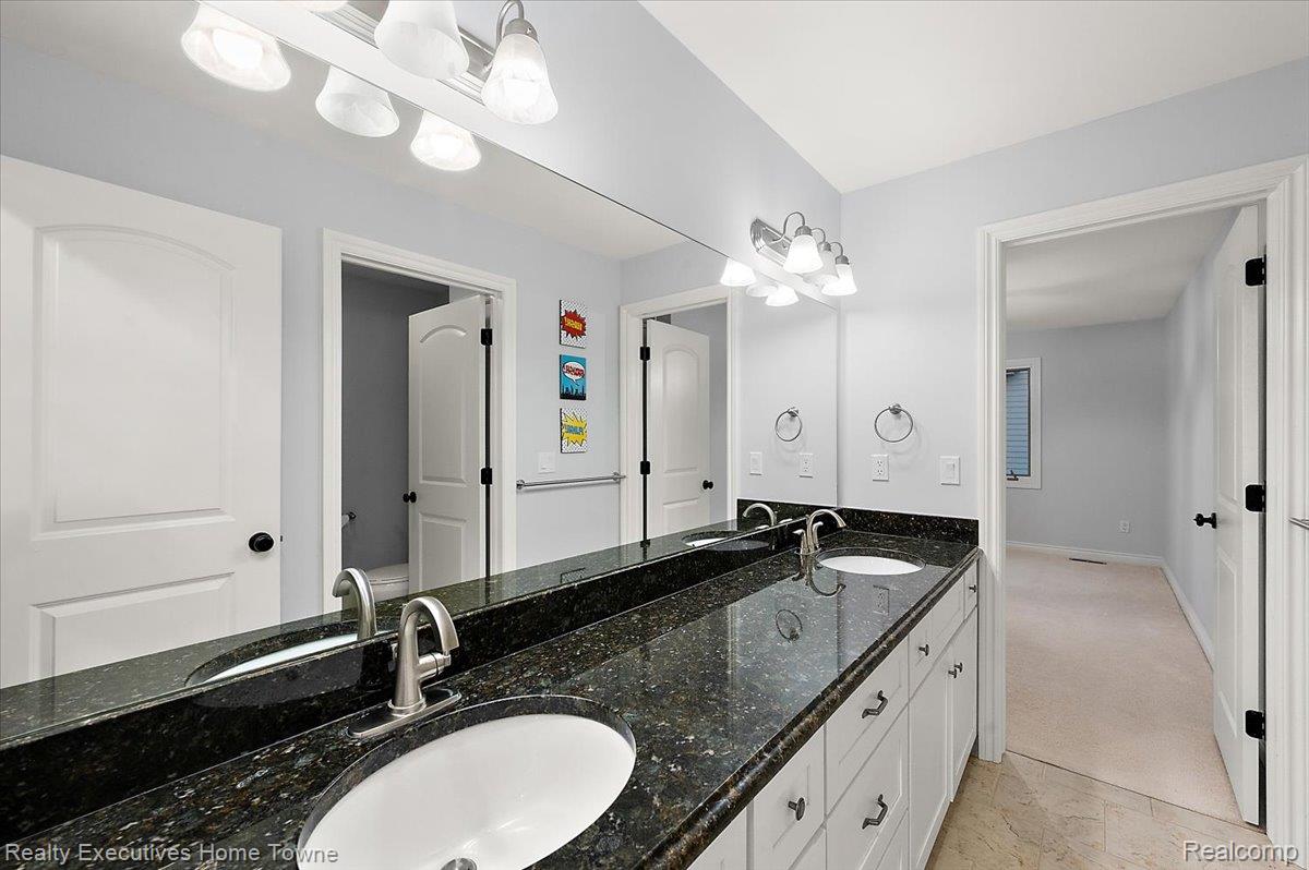 2919 North Addison Circle Rochester, MI 48306 - Photo 46 of 69 Dual vanity with dark stone countertop, undermount sinks, and chrome faucets