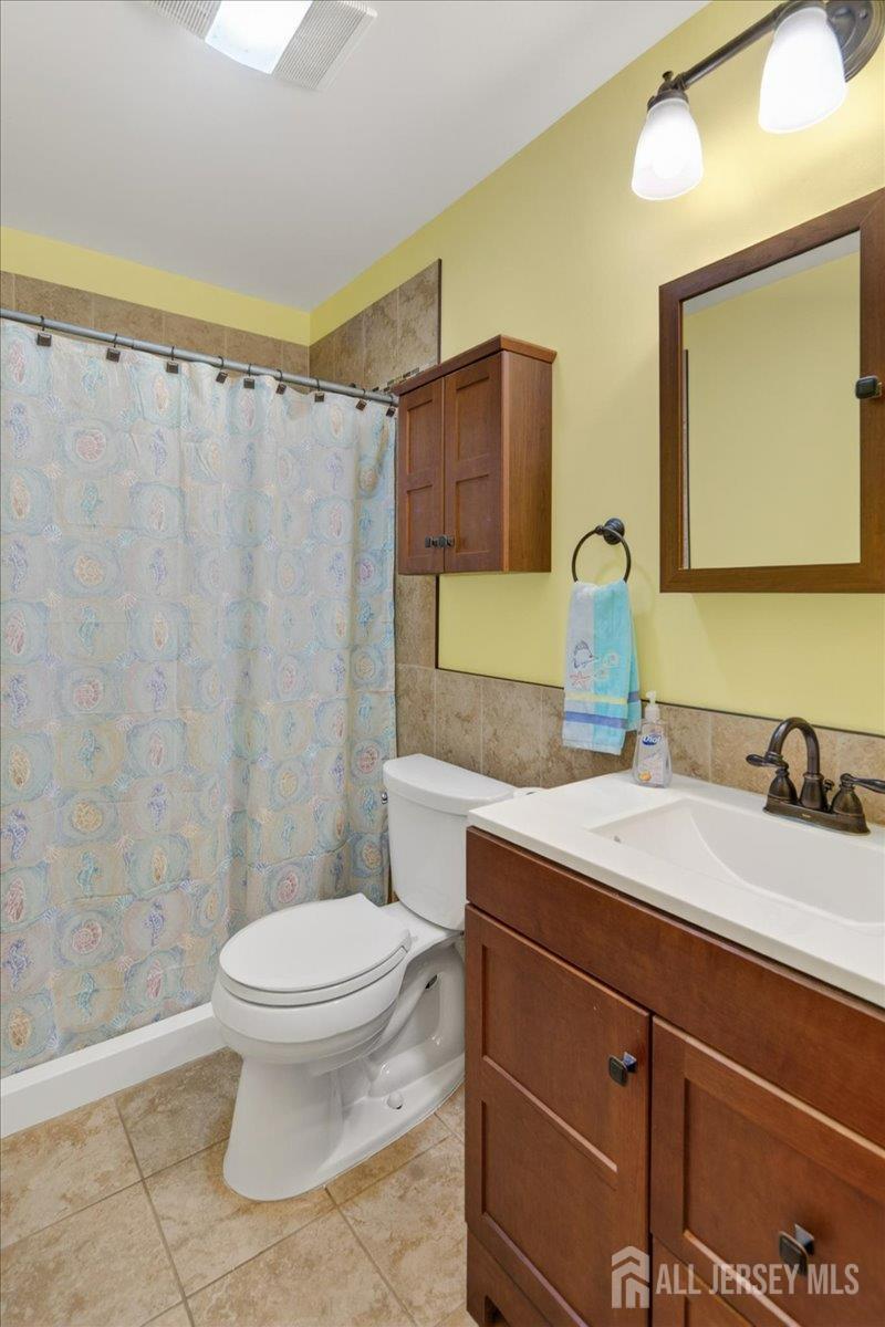 13 Comstock Road Edison, NJ 08817 - Photo 18 of 22 a bathroom with a granite countertop sink mirror vanity and toilet