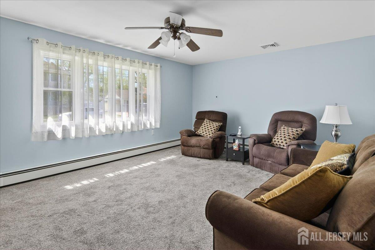 13 Comstock Road Edison, NJ 08817 - Photo 3 of 22 a living room with furniture a window and a chandelier