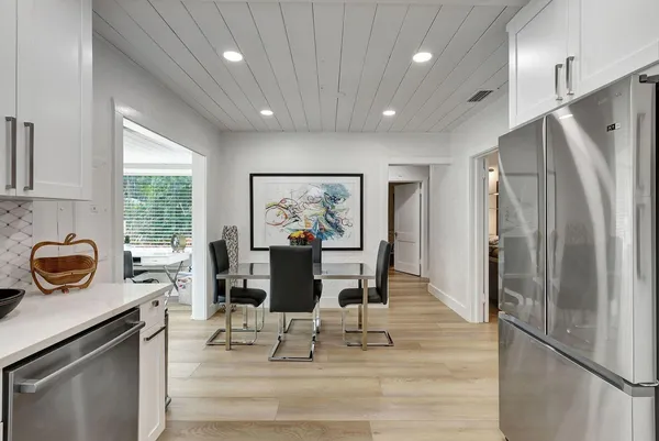 a view of a dining room with furniture a rug and wooden floor