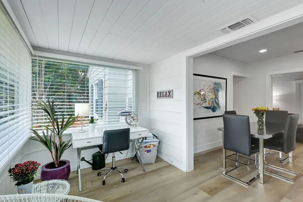 a view of a workspace with furniture and a window