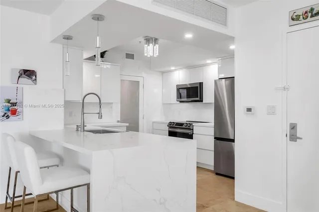 a kitchen with stainless steel appliances a sink stove and refrigerator