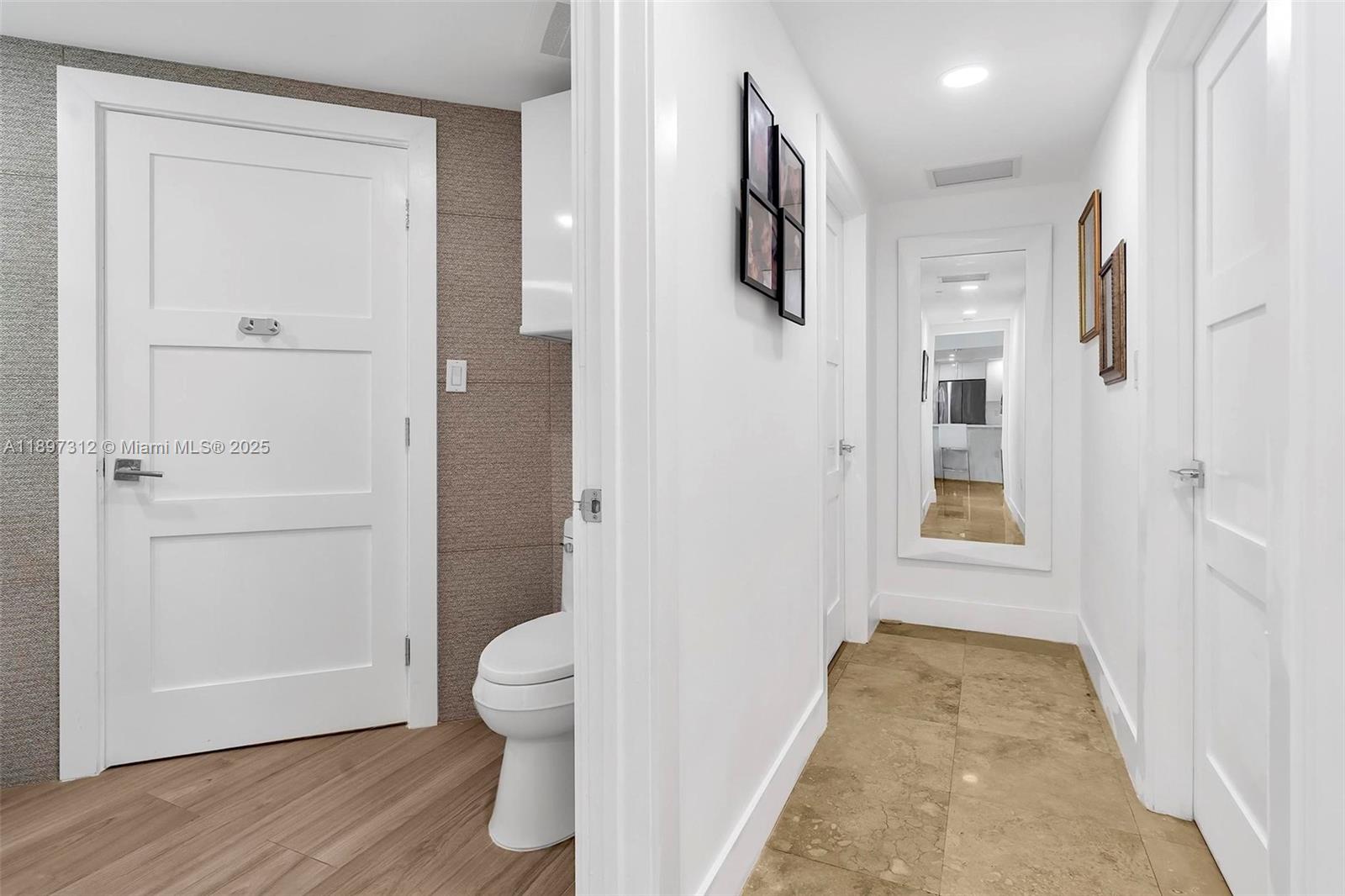 9066 Southwest 73rd Court, Unit 2110 Miami, FL 33156 - Photo 24 of 45 a view of a hallway with toilet and wooden floor
