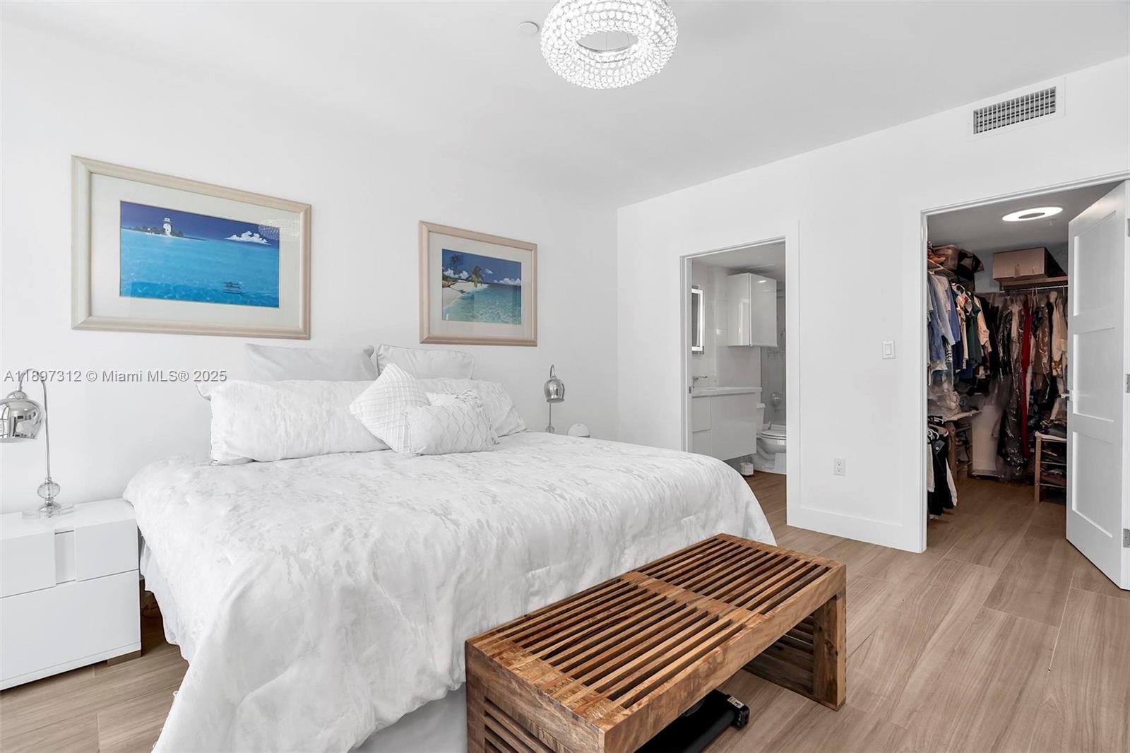 9066 Southwest 73rd Court, Unit 2110 Miami, FL 33156 - Photo 32 of 45 a bedroom with a bed and a chandelier