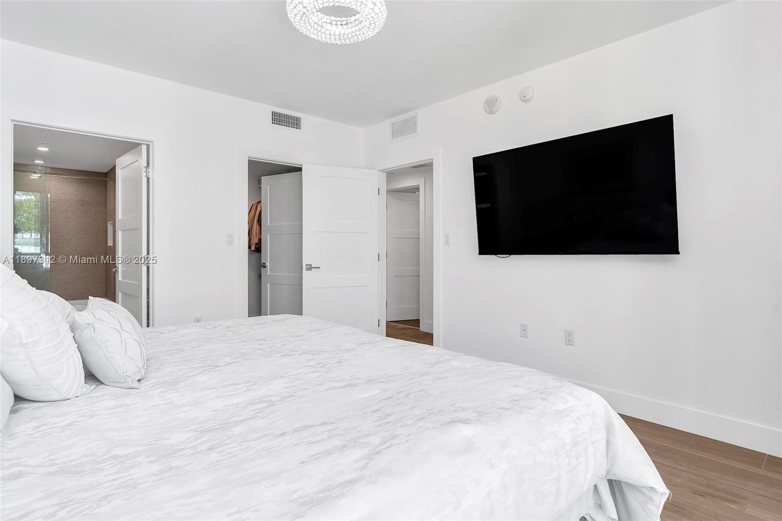 9066 Southwest 73rd Court, Unit 2110 Miami, FL 33156 - Photo 33 of 45 a bedroom with a bed and a flat screen tv