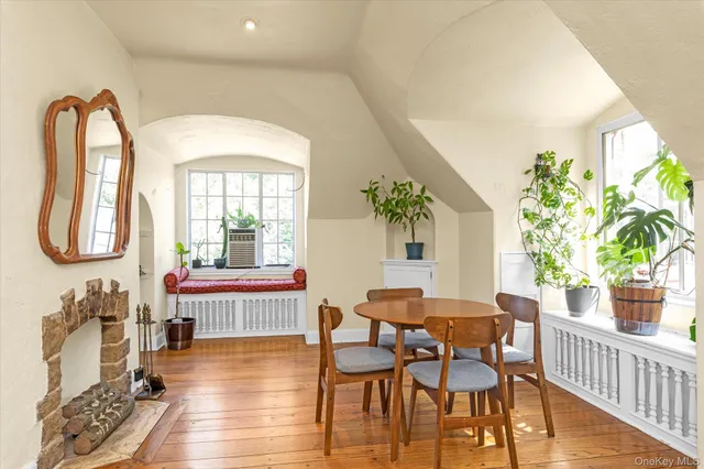 a dining room with furniture potted plants and wooden floor