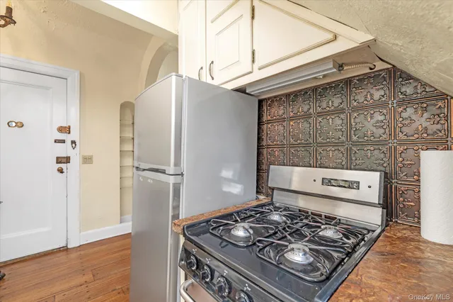 a kitchen with a stove and a wooden floor