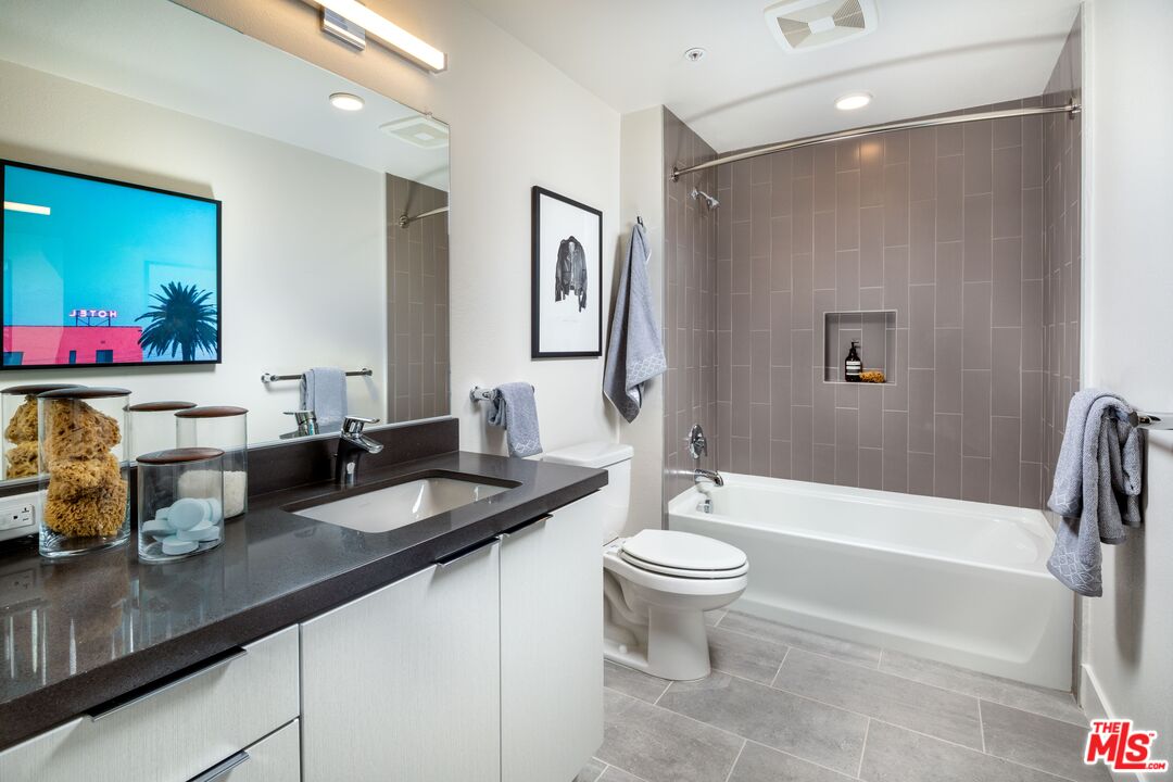 1101 North Main Street, Unit C450 Los Angeles, CA 90012 - Photo 6 of 35 a bathroom with a granite countertop sink mirror toilet and bathtub