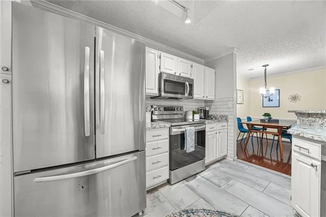 a kitchen with stainless steel appliances granite countertop a refrigerator stove and sink