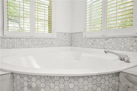 a bathroom with a bathtub and next to a window