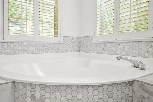 a bathroom with a bathtub and next to a window