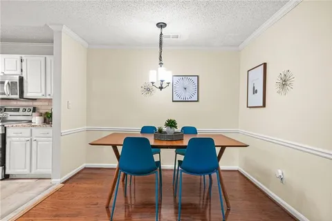a view of a dining room with furniture wooden floor and a chandelier