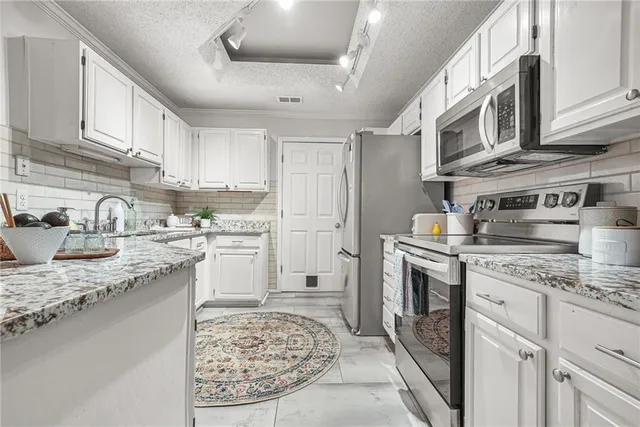 a kitchen with stainless steel appliances granite countertop a sink a stove and cabinets