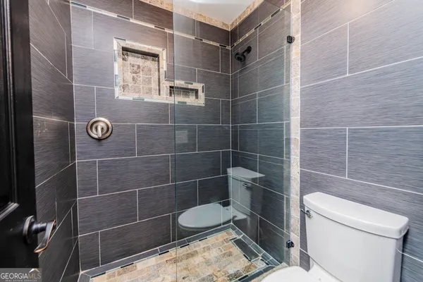 a bathroom with a toilet a window and shower