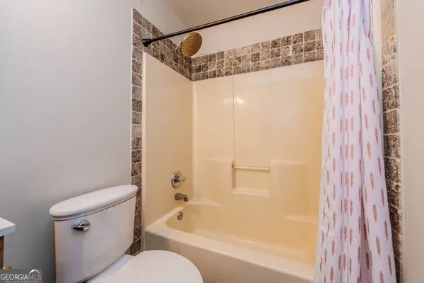 a bathroom with a shower a toilet and a bathtub