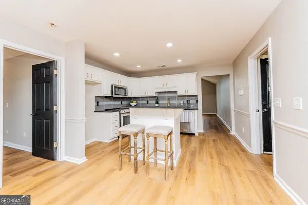 a kitchen with stainless steel appliances kitchen island granite countertop a refrigerator and a stove top oven