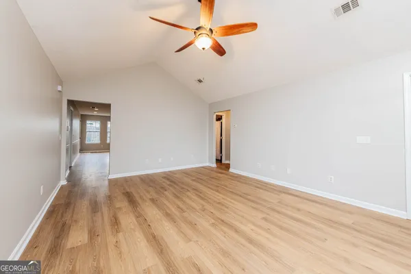 a view of empty room with wooden floor