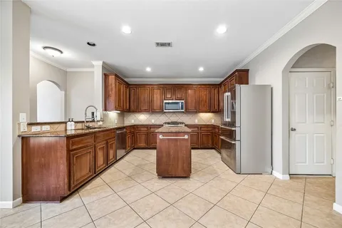 a kitchen with stainless steel appliances granite countertop a refrigerator a sink and a stove