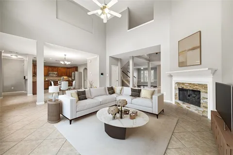 a living room with furniture a fireplace and a chandelier