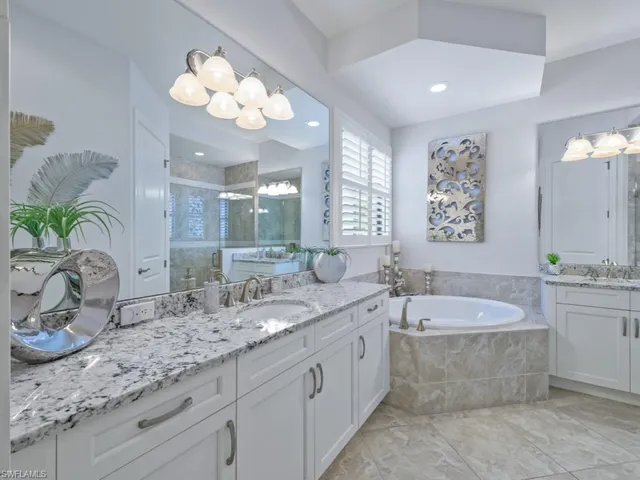 a bathroom with a granite countertop sink mirror and bathtub