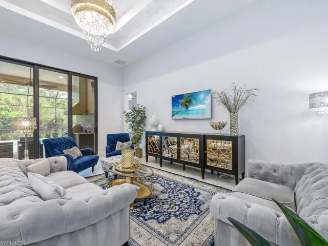 a living room with furniture a chandelier and a large window