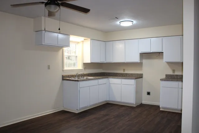 a kitchen with granite countertop white cabinets and white appliances