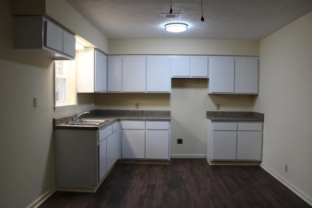a kitchen with granite countertop cabinets stainless steel appliances and a window