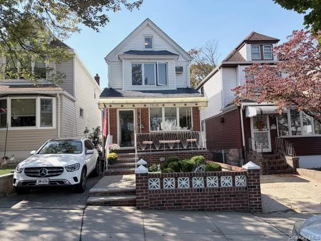a view of a white house with large windows and a table and chairs