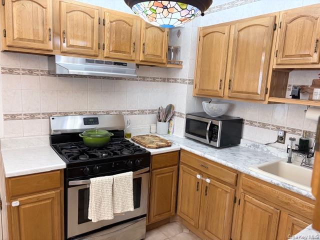 78-18 65th Street Queens, NY 11385 - Photo 3 of 25 a kitchen with stainless steel appliances granite countertop a sink a stove and cabinets