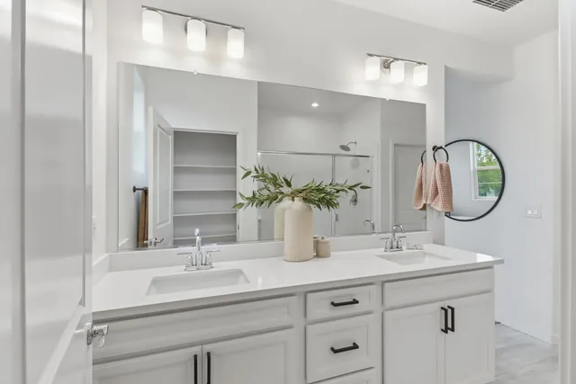 a bathroom with a double vanity sink and a mirror