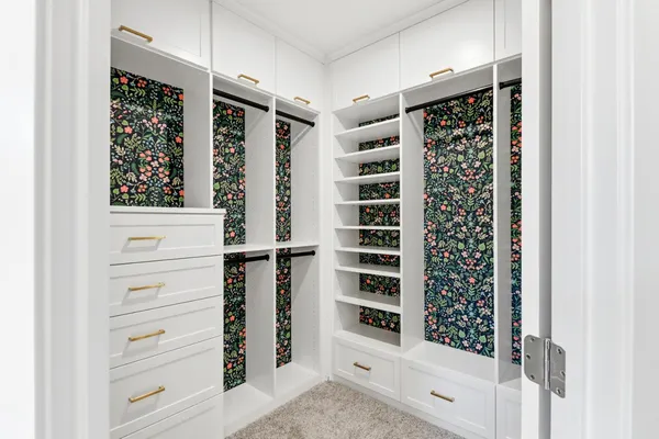 a view of walk in closet with clothes and shoes