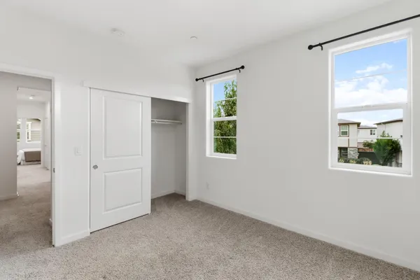an empty room with windows and closet