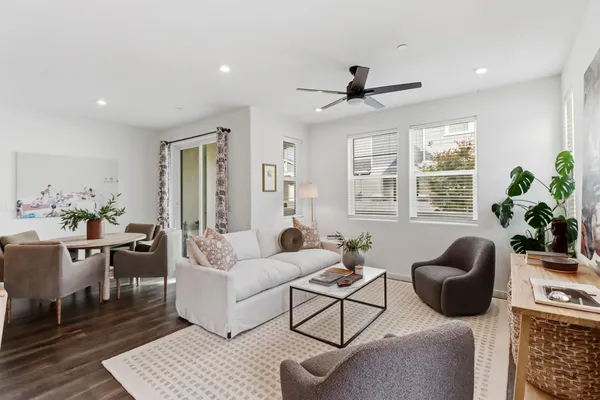 a living room with furniture a window and a potted plant