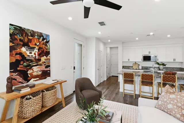 a living room with stainless steel appliances kitchen island granite countertop furniture a rug and a kitchen view