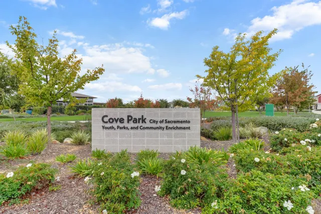 a sign that is sitting in the middle of a lake with a yard