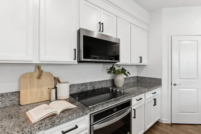 a kitchen with granite countertop a sink and a stove top oven